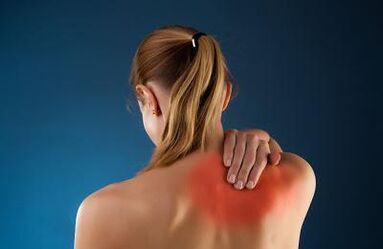 Back pain in the shoulder blades of a woman. 